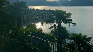 A serene lakeside view with mountains in the background and a clear sky. - Villa Angelina (Cannero Riviera)