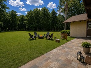 A backyard with a fire pit, outdoor seating, and a patio area. - Comfortable, Peaceful Stay Near Tampa & Plant City (Seffner)