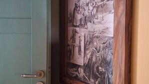 Une porte dotée d’un trou de serrure et d’une poignée en métal, située à côté d’une photographie en noir et blanc encadrée représentant une scène historique.