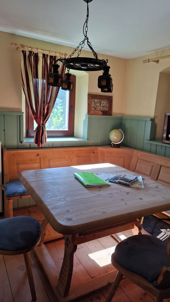 A wooden table with a green notebook, a globe, and a framed picture on the wall. - An Oasis of Peace in Haselbach: Relaxation in the Countryside. The Idyllic Haselbach Estate (Olbernhau)