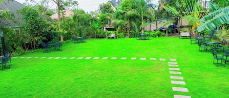 A well-maintained garden with a lawn, stone pathway, and outdoor seating area.