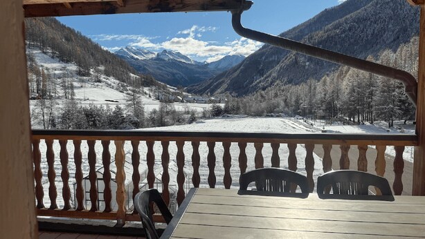 A wooden balcony with a view of a snow-covered valley and mountains. - Gites Simond welcomes you to Arvieux in the heart of the Queyras Regional Park, (ARVIEUX)