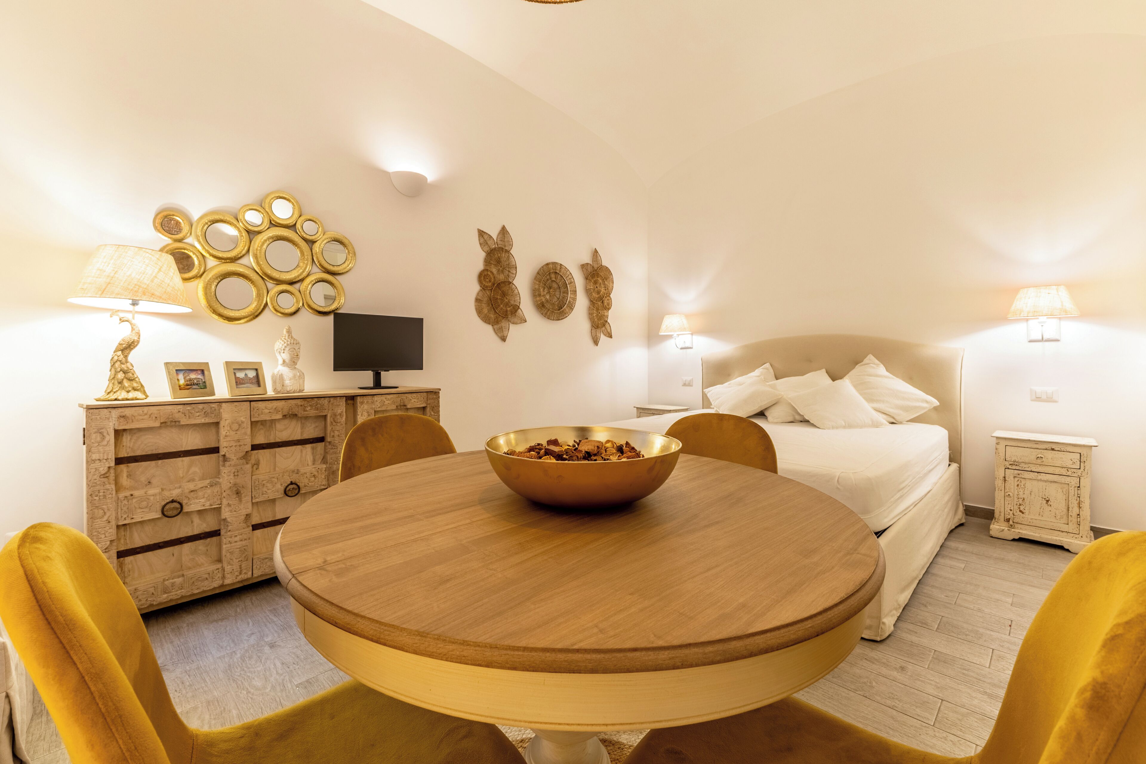 Ein gemütliches Schlafzimmer mit einem Bett, Nachttischen und einem runden Esstisch mit Stühlen.