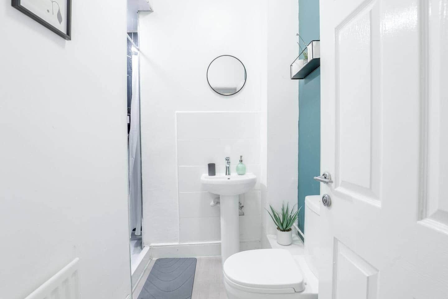 Un baño pequeño con inodoro, lavamanos y espejo.