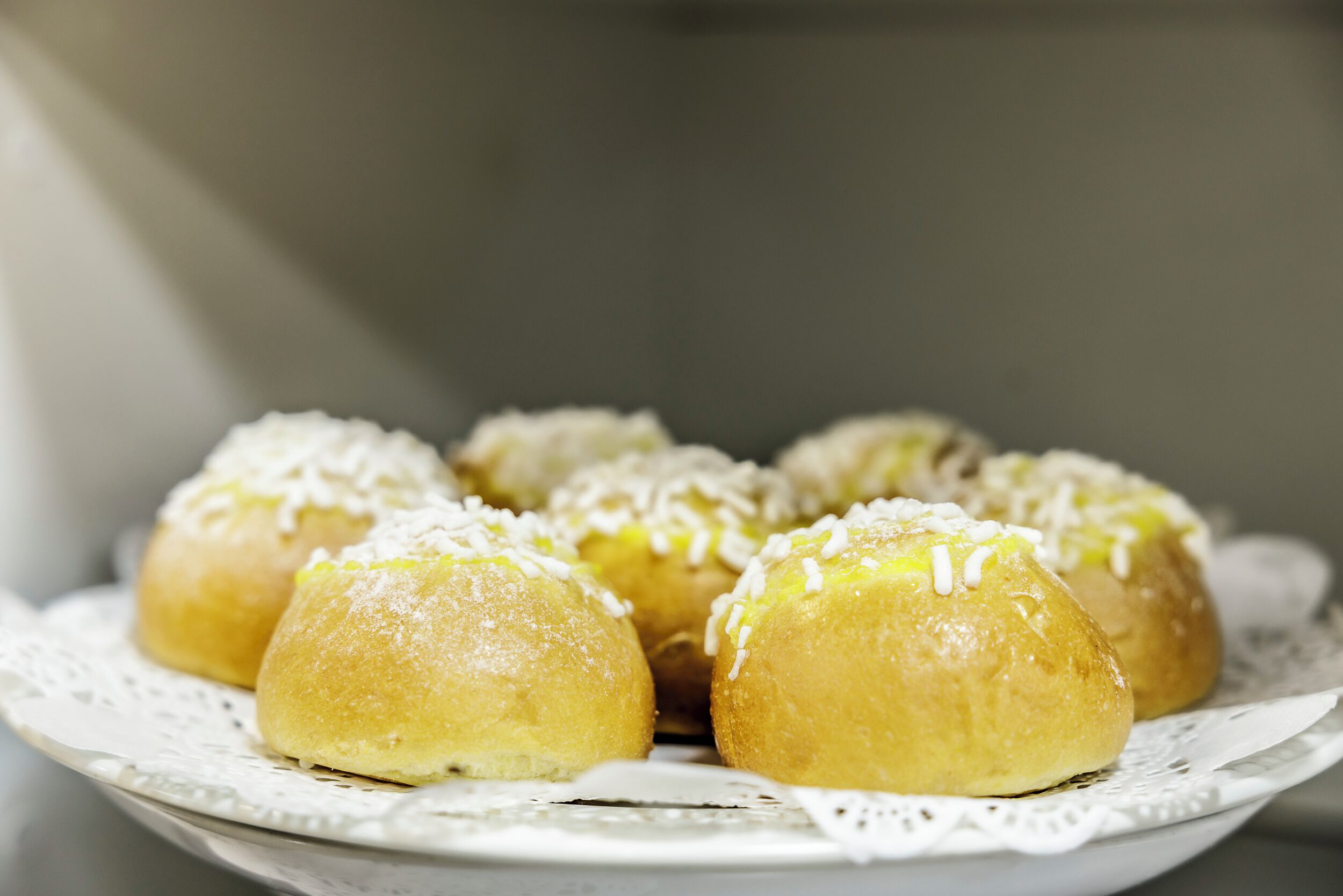 A plate of round pastries with white toppings.
