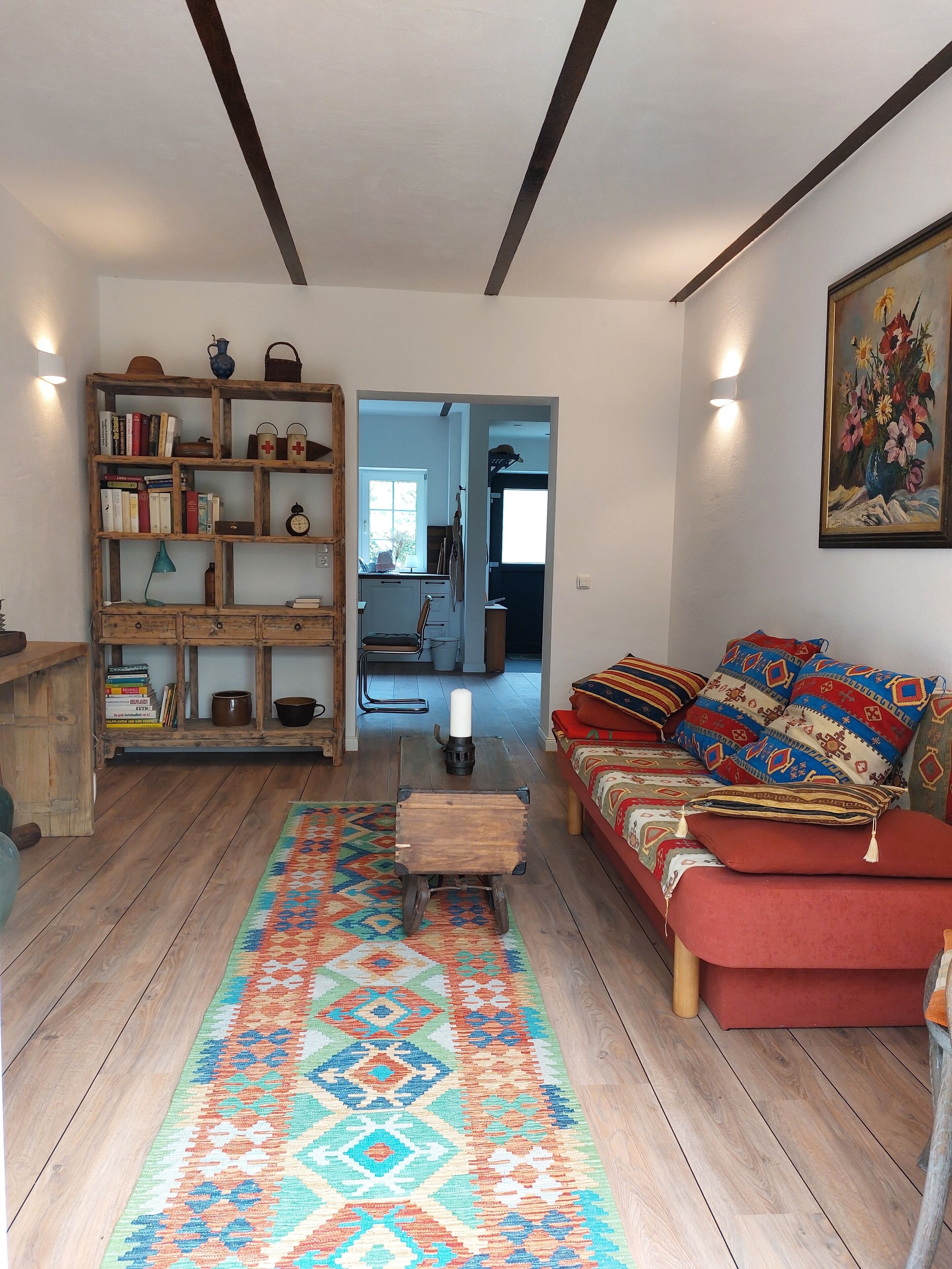 Ein gemütliches Wohnzimmer mit einer Holzhülle, einem roten Sofa und einem farbenfrohen Teppich.