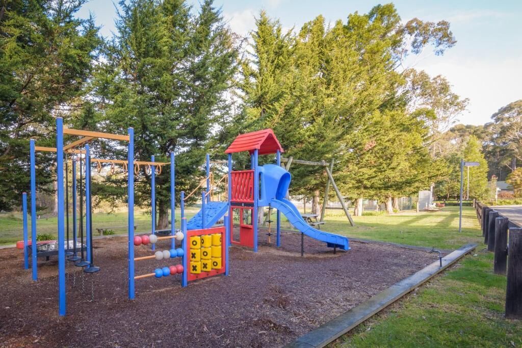 Ein Spielplatz mit Rutsche, Klettergerüsten und einem Ballspielbereich.