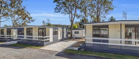 Filas de casas móviles modernas con ventanas amplias y un camino de grava.