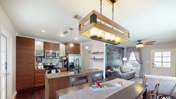 A modern kitchen with wooden cabinets, stainless steel appliances, and a central island. - Walkable Dixieland District Gem with Yard (Lakeland)