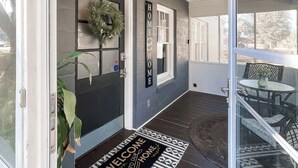 A front porch with a welcome mat, a door with a wreath, and a 'HOME' sign. - Walkable Dixieland District Gem with Yard (Lakeland)
