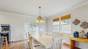 A dining area with a wooden table and chairs, a chandelier, and a coffee station. - Walk to Lake Arrowhead! Family Home w/ Games (Lake Arrowhead)