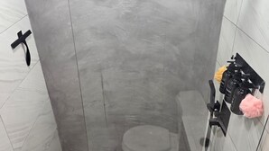 A modern shower with a glass door, a handheld showerhead, and a wall-mounted faucet. - Ponce Pueblo Central Apt (Ponce)
