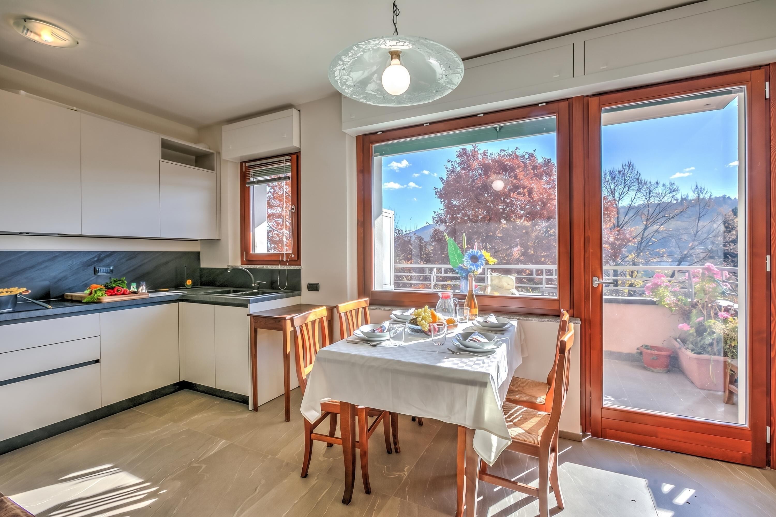 Una cucina moderna con zona pranzo, ampie finestre e vista sull'esterno.