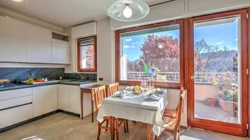 Una cucina moderna con zona pranzo, ampie finestre e vista sull'esterno.
