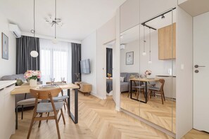 Dining space with a table, comfortable chairs, and large windows. - Stylish Apartment | 800 m from Spodek and Balcony (Katowice)