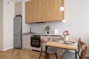 Another angle of the kitchen with full appliances and dining setup. - Stylish Apartment | 800 m from Spodek and Balcony (Katowice)
