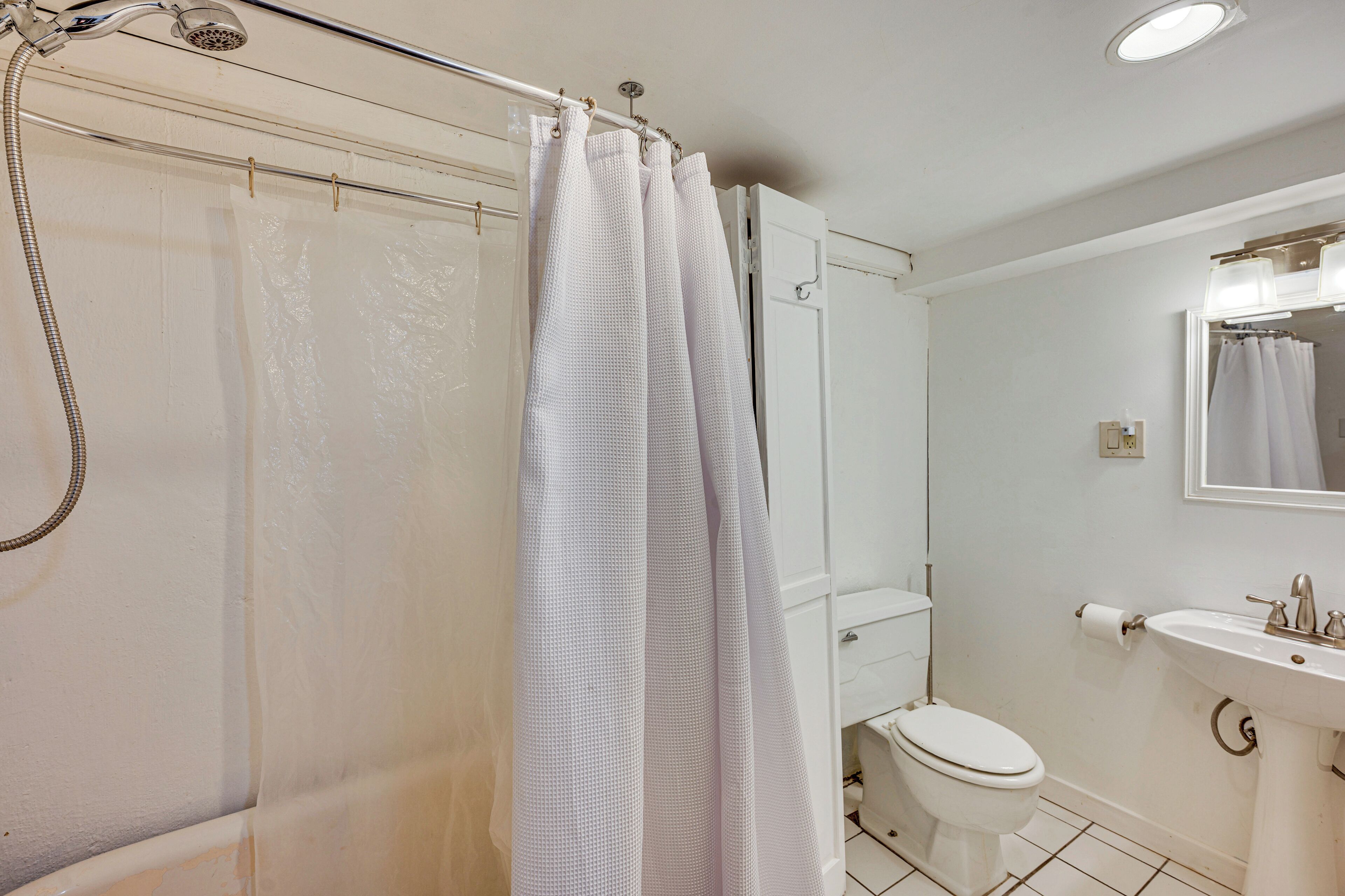 Ein Badezimmer mit Dusche, Toilette und Waschbecken.