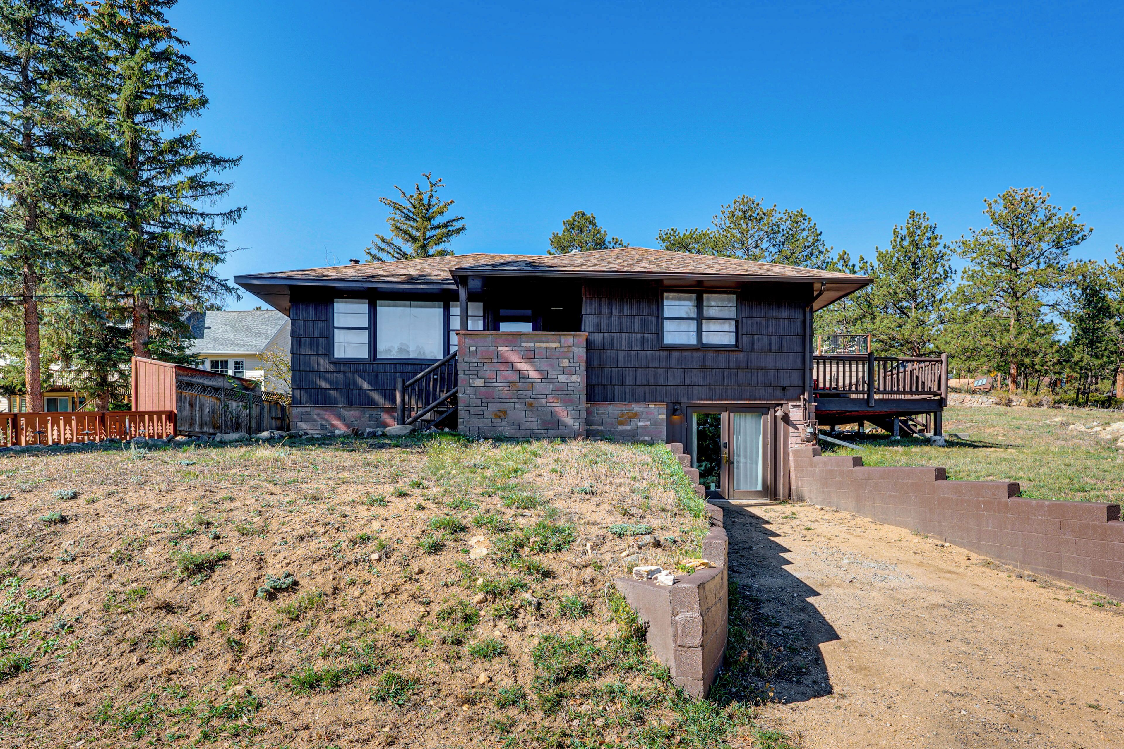 A two-story house with a stone foundation and a wooden exterior.