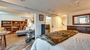 A well-lit room with a bed, a sofa, a small table, and a bookshelf. - Mtn-view Retreat w/ Deck & Hot Tub in Estes Park! (Estes Park)