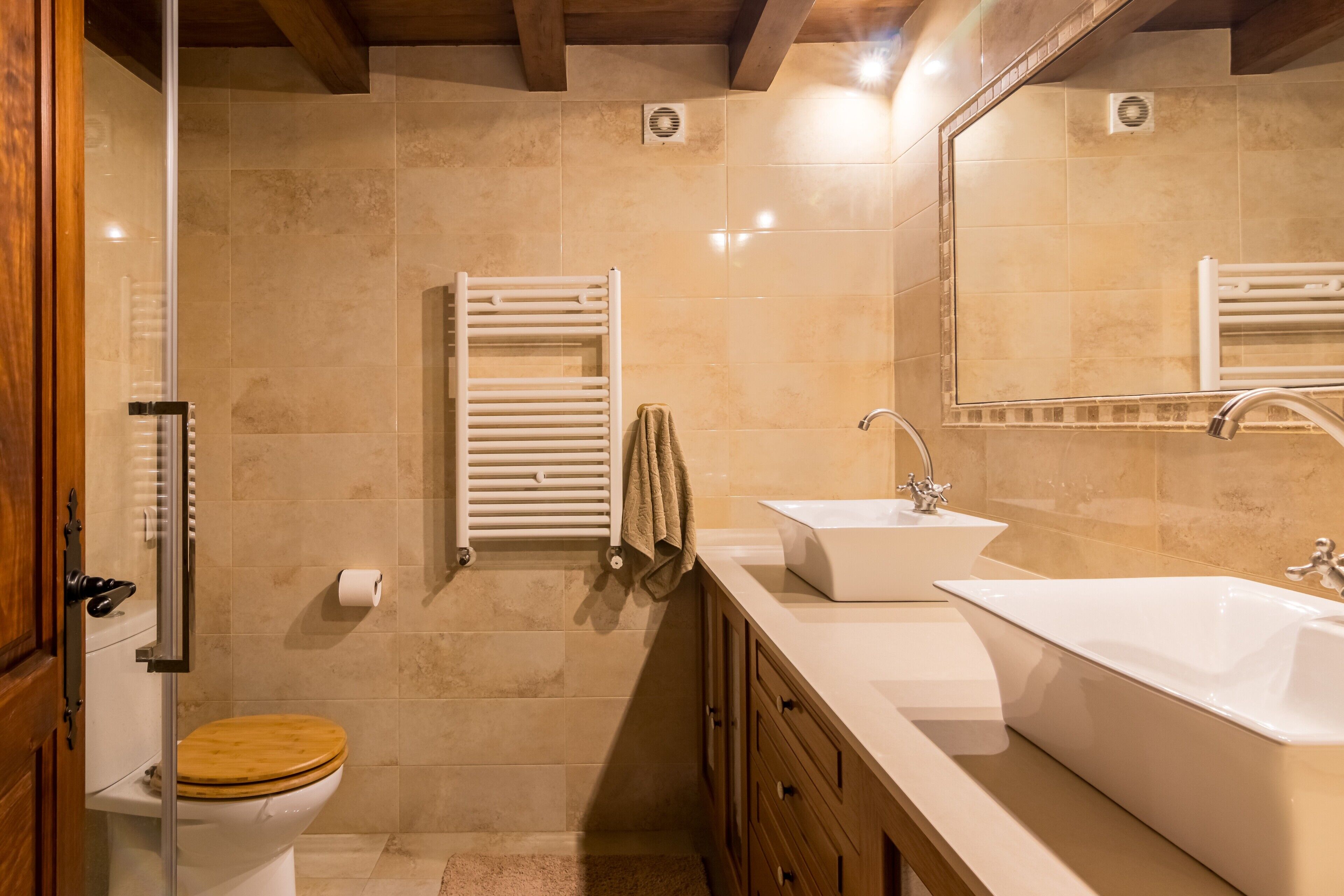 Une salle de bain équipée de toilettes, d’un lavabo, d’un miroir et d’un porte-serviettes.