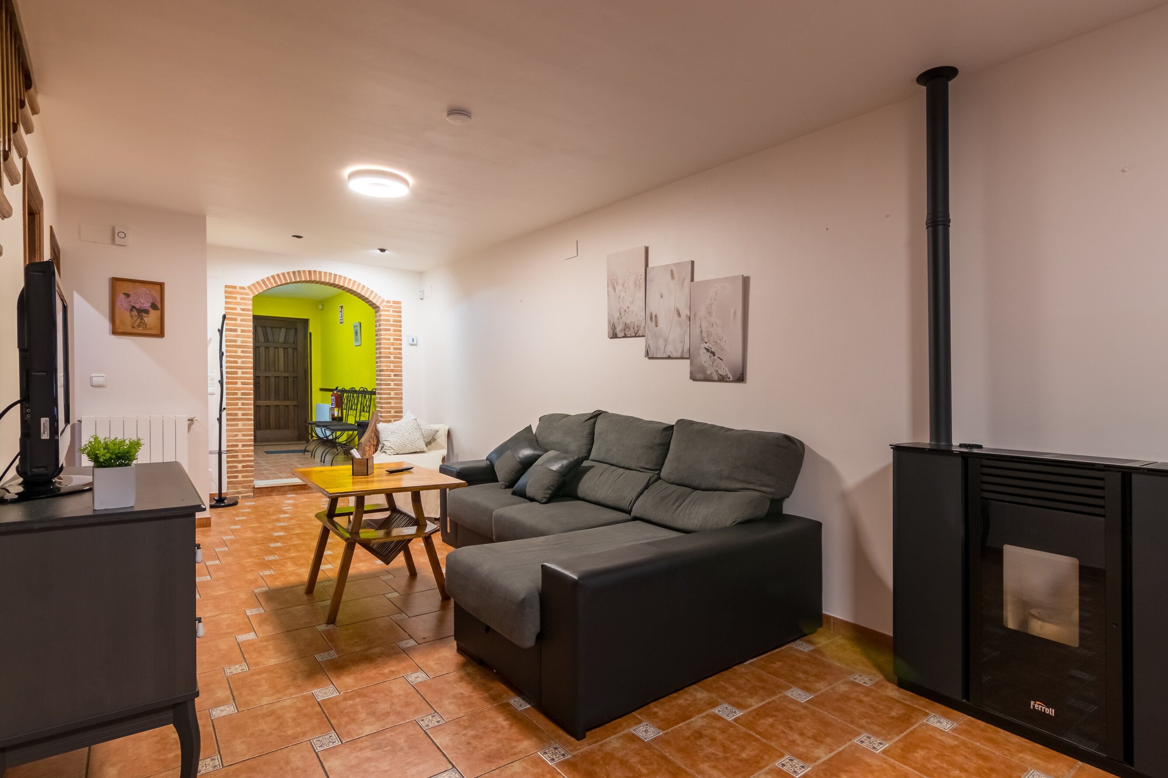Una sala de estar con un sofá, una mesa, una chimenea y una puerta verde brillante.