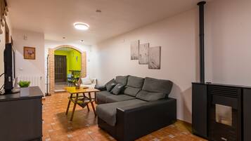 Una sala de estar con un sofá, una mesa, una chimenea y una puerta verde brillante.
