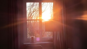 A room with a window, a lamp, and a chair. - Apartment 'Sonnenkuss' with Private Terrace, Shared Garden & Wi-Fi (Pellworm)