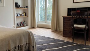 A bedroom with a bed, a desk with a chair, a bookshelf, a window with curtains, and a painting on the wall. - Domaine les Darbonnets (Chavannes-sur-Reyssouze)