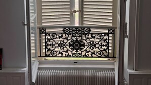 A room with a double door, a radiator, and a decorative metal gate. - Domaine les Darbonnets (Chavannes-sur-Reyssouze)