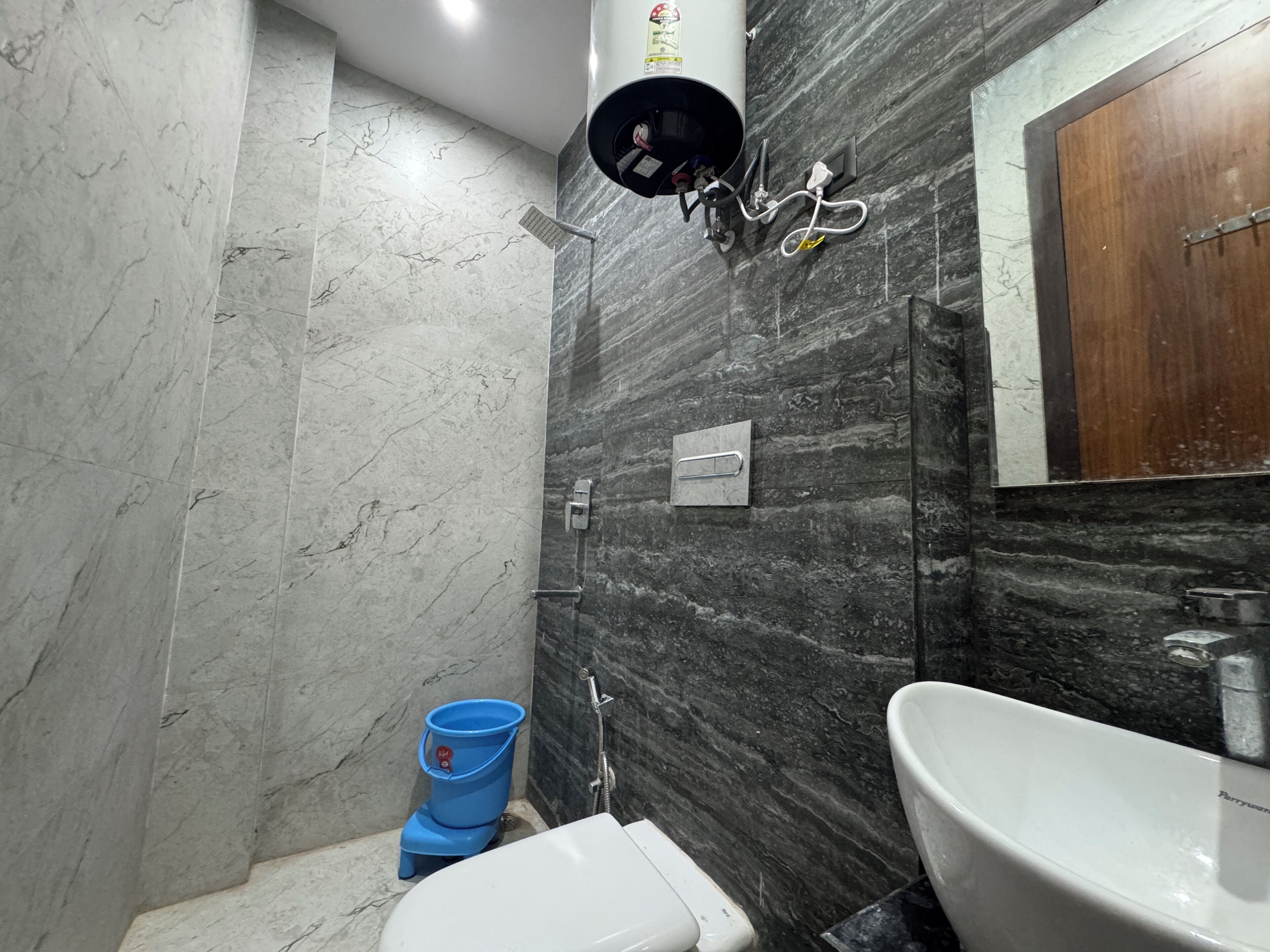 A bathroom with a white toilet, a sink, and a shower area.