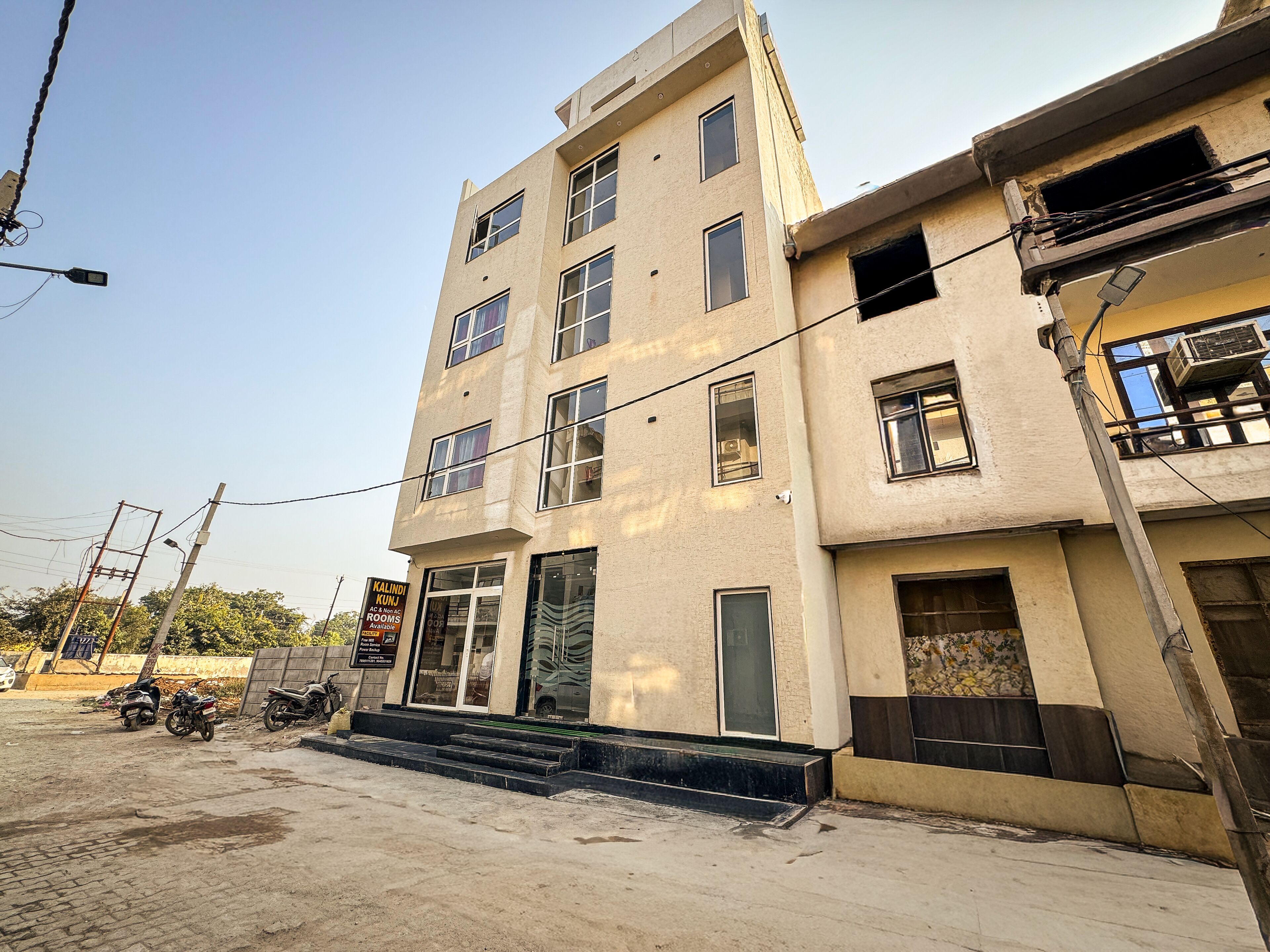 A multi-story building with a flat facade, multiple windows, and a visible entrance with steps leading up to it.