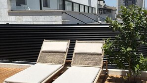 A rooftop terrace with two sun loungers and a small tree. - Artemis (Tiberias)