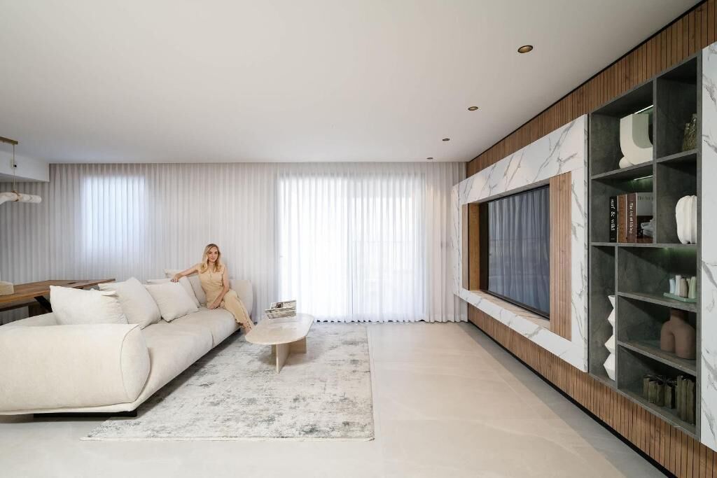 A modern living room with a sofa, coffee table, and built-in shelving.