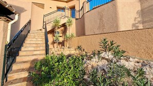 A building with a stone staircase, metal railings, and a stone wall with plants. - Cozy villa with infinity pool in the mountains of Sierra Cabrera (TURRE)