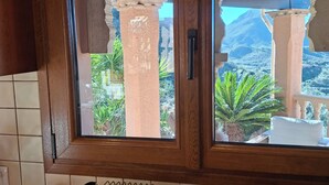 A kitchen with a window view of a mountainous landscape, a toaster, and a kettle on the counter. - Cozy villa with infinity pool in the mountains of Sierra Cabrera (TURRE)