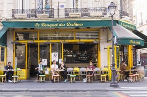Een café genaamd 'Le Bouquet des Archives' met terras en een goed zichtbaar menu.