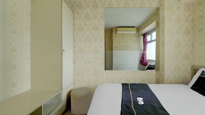 A hotel room with a bed, wardrobe, and a mirror reflecting a window and a curtain. - Hotel O Kalibata City Residence (Jakarta)