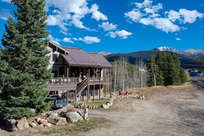 A two-story lodge with a balcony, a stone foundation, and a view of mountains. - Ski Inn Condo 1 Bedroom Condo (Winter Park)