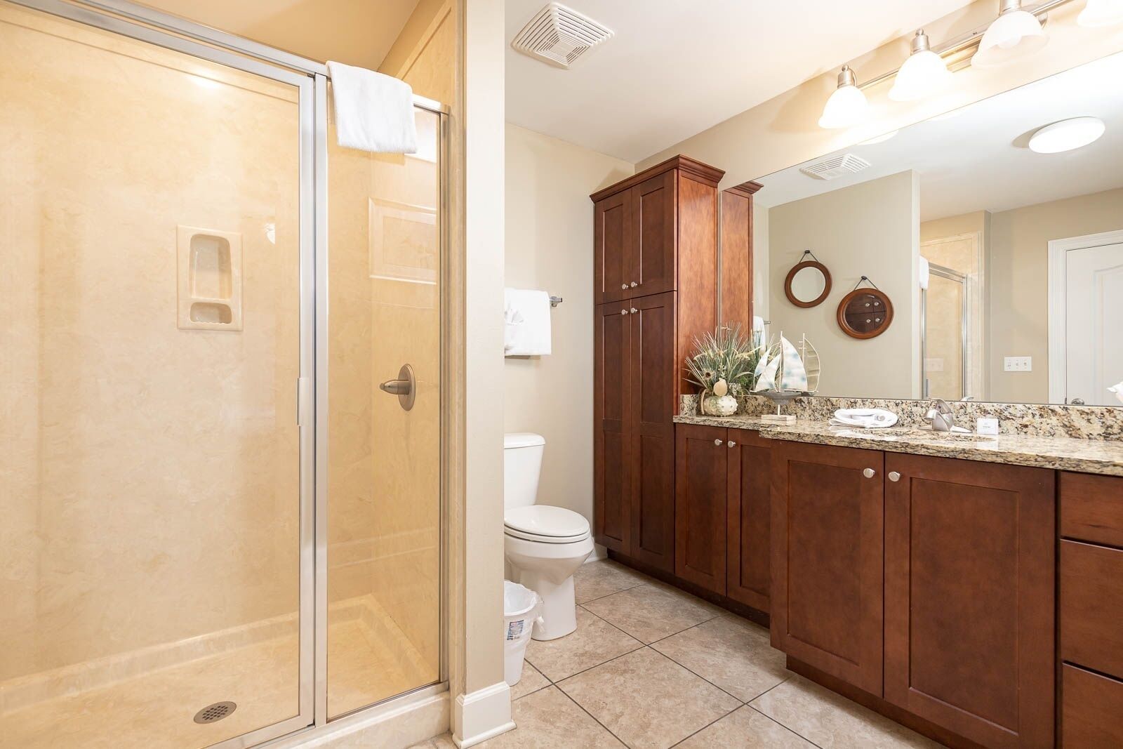 Een badkamer met een inloopdouche, toilet en een wastafel met een grote spiegel.