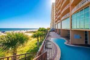 A hotel with a pool, beach view, and a clear sky. - Phoenix Gulf Shores by Brett/Robinson Vacations (Gulf Shores)