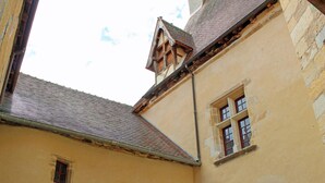 A narrow alleyway with buildings featuring stone walls and traditional architecture. - Charming medieval house in the heart of Hérisson (Hérisson)