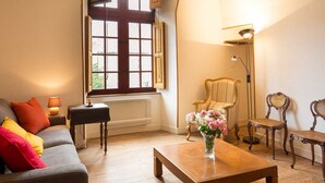 Una sala de estar con un sofá, una mesa de centro, una silla y una lámpara.