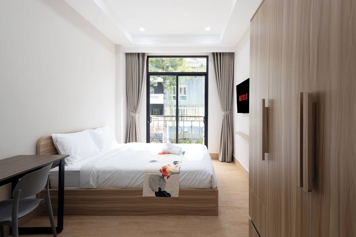 Ein modernes Hotelzimmer mit Bett, Schreibtisch und Fernseher.