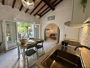 Una cocina con comedor, un lavamanos y vistas al exterior.