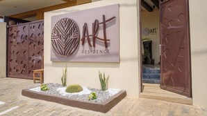 Entrada de un edificio con un letrero que dice 'ART RESIDENCE'.