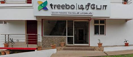 Un edificio con un letrero que dice "treebo | paradise" y "GOLDEN PARADISE".