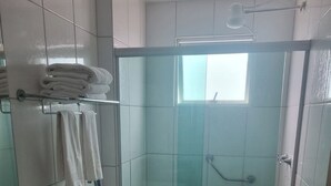 A bathroom with a glass-enclosed shower, a toilet, and a granite countertop sink. - Modern apartment with complete leisure area and access to the Golden Dolphin. (Caldas Novas)