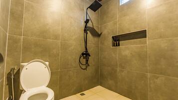 A bathroom with a toilet, shower, and a shelf with toiletries.