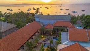 A resort with multiple buildings, a swimming pool, and boats on the water.