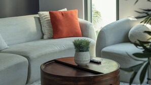 A modern living room with a light grey sofa, a round wooden coffee table, and a small potted plant. - Resort-Style - 4BR Villa, Arabian Ranches 3 (Dubai)